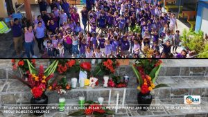 Students and staff of St. Michael R.C. School in San Felipe wear purple and hold a vigil to raise awareness about domestic violence